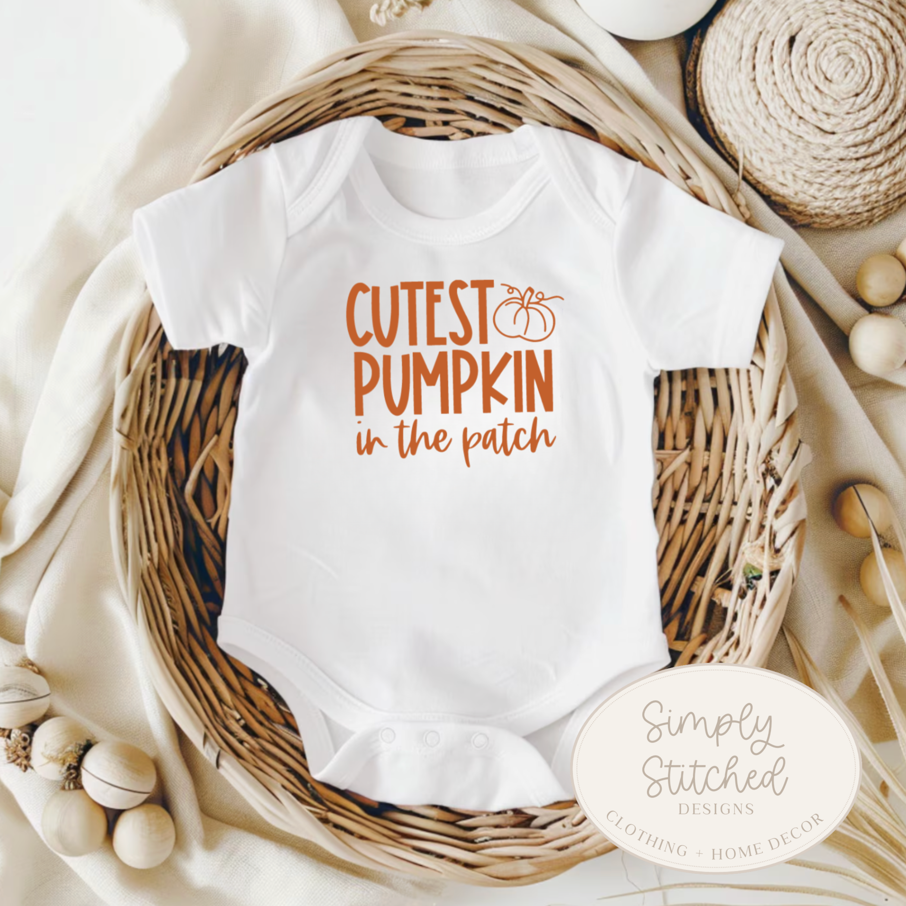 White baby onesie with 'Cutest Pumpkin in the Patch' text on a neutral background